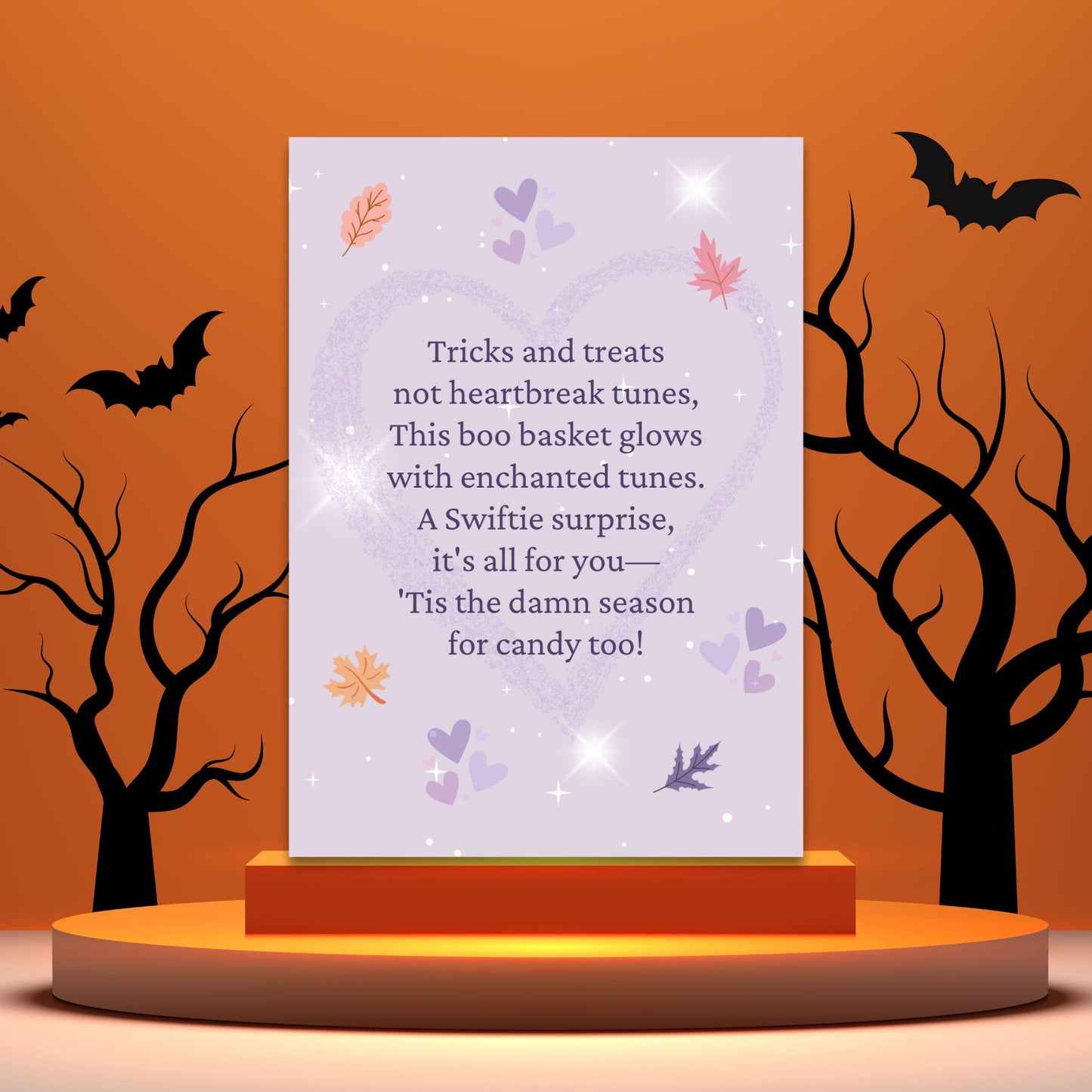 Halloween-themed card with text on a stand against an orange background with bats and trees.