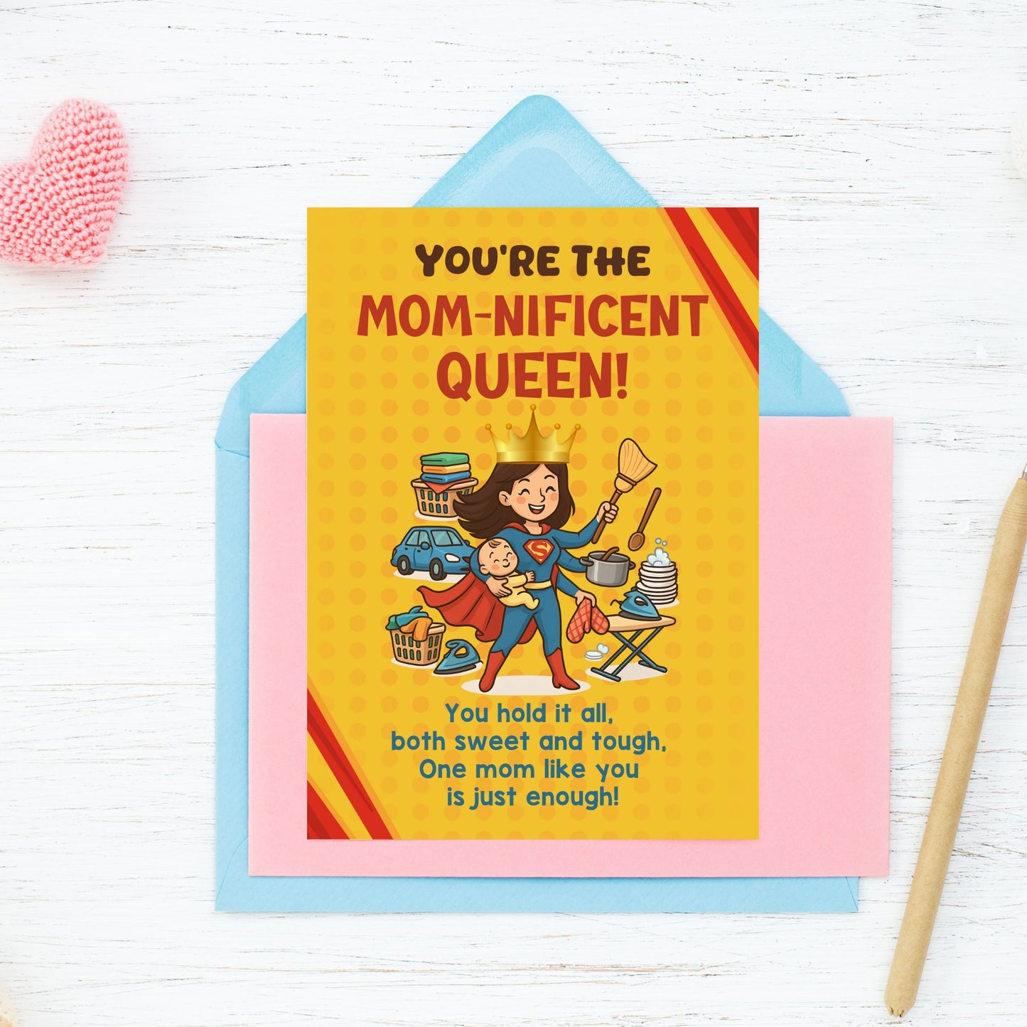 Printable 5x7 Mother’s Day card featuring a cartoon Supermom juggling a baby, cooking, ironing, and housework with a crown and cape, titled “You’re the Momnificent Queen.” Instant download PDF.