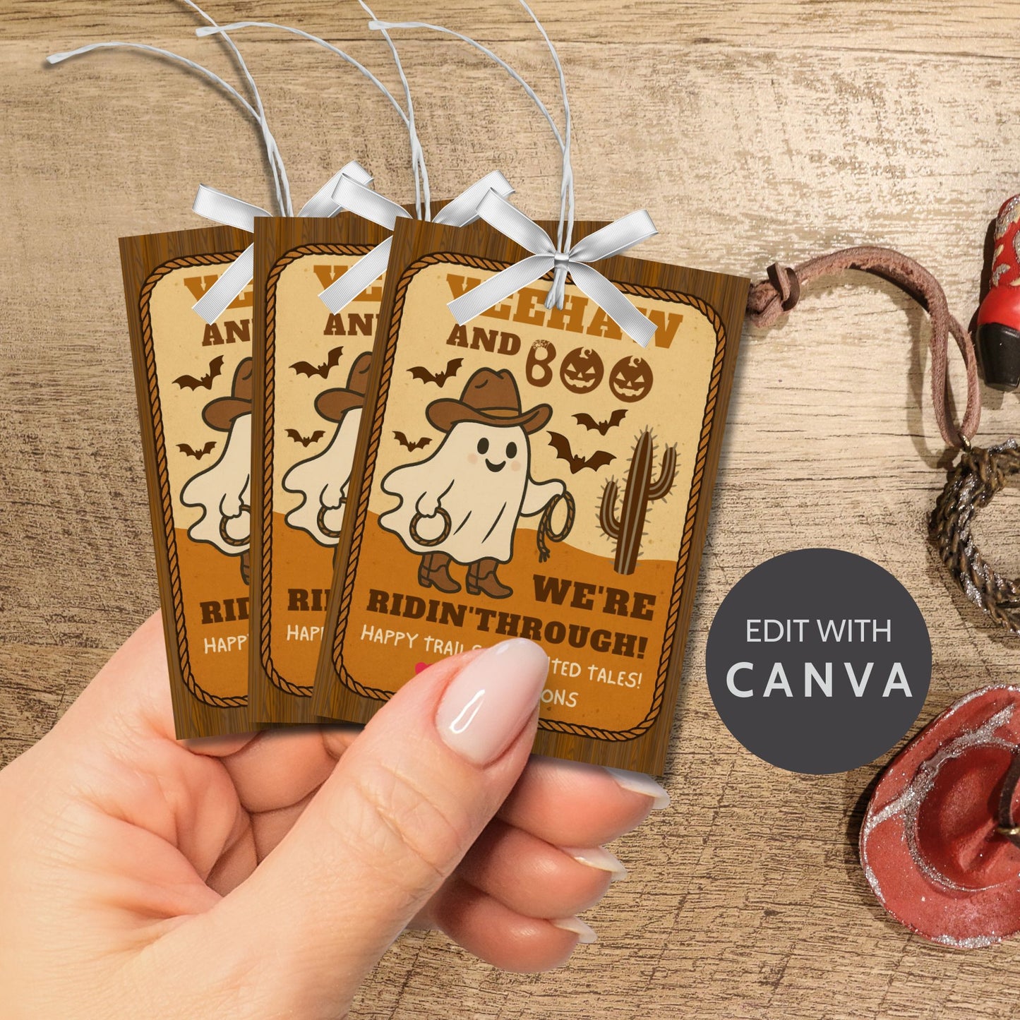Three Halloween-themed tags held by a hand on a wooden surface with 'Edit with Canva' text.