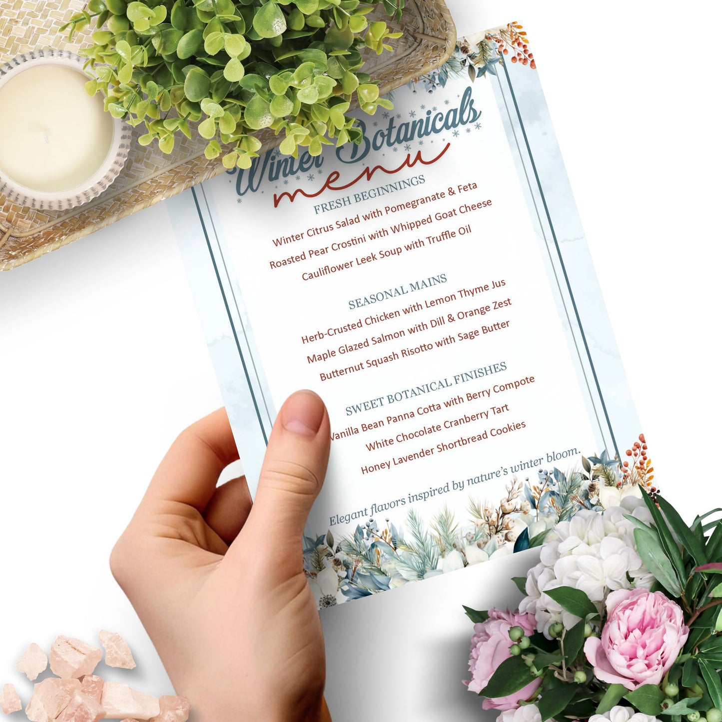 Hand holding a menu with floral and botanical design elements on a white background