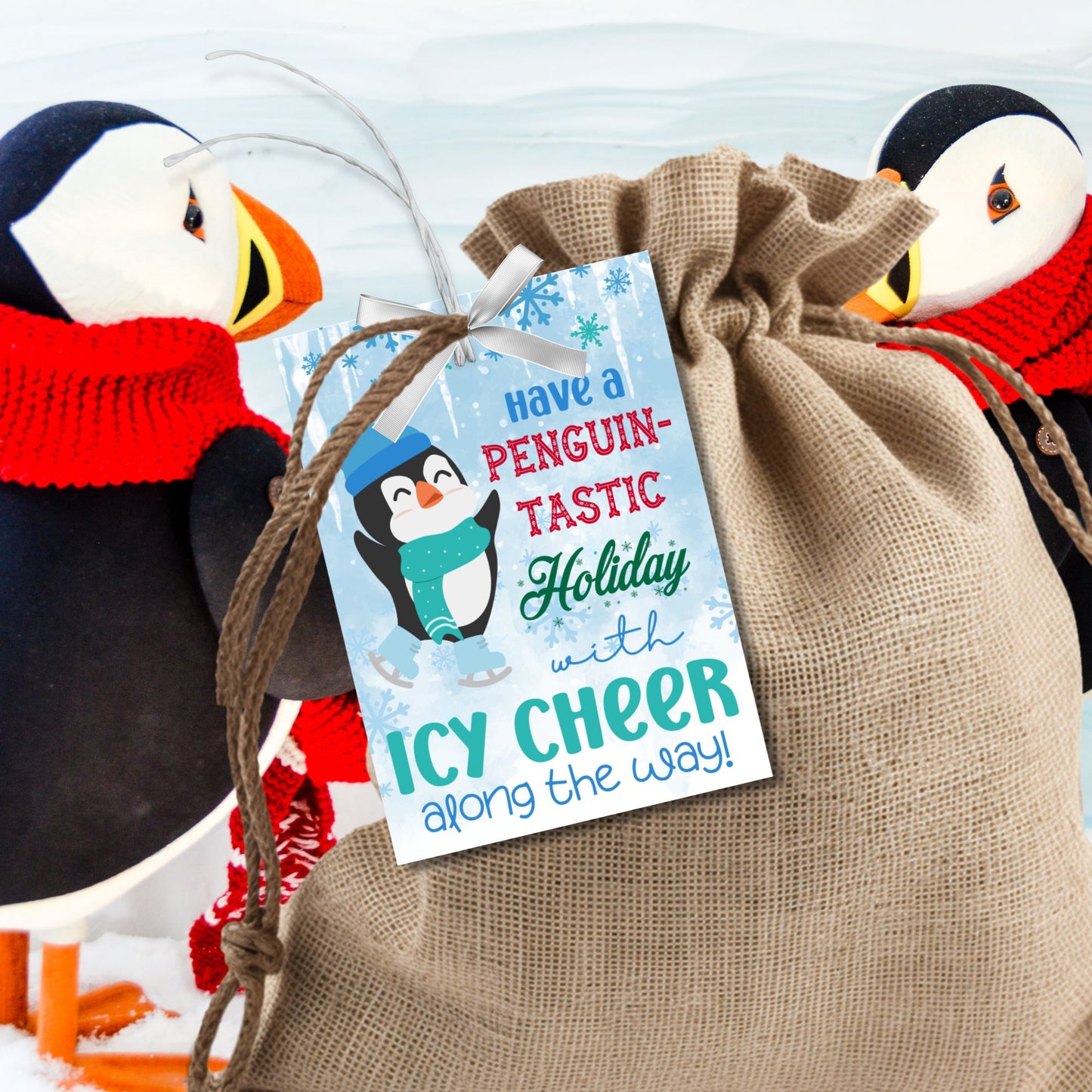 Penguin-themed Christmas gift tags featuring a happy penguin wearing a blue hat and green scarf, surrounded by snowflakes. The text reads 'Have a Penguin-tastic Holiday with Icy Cheer Along the Way!'