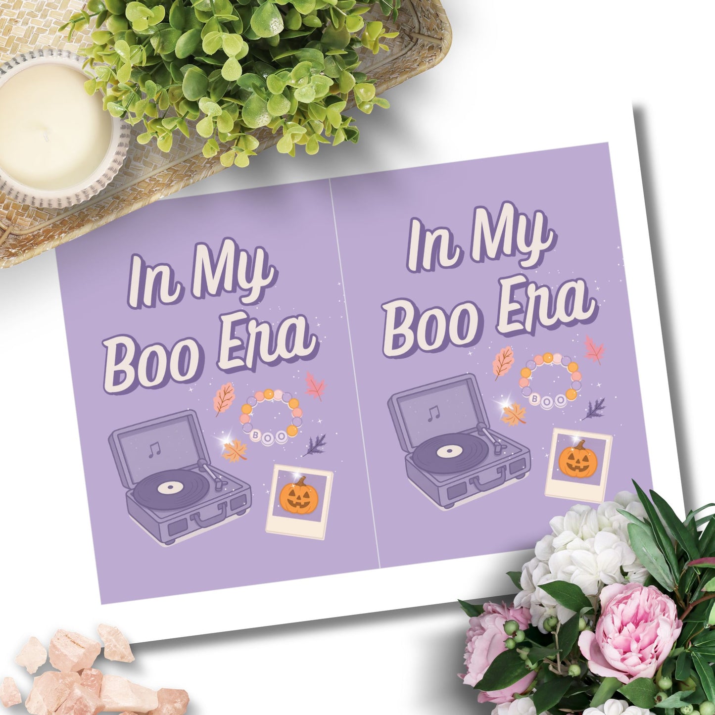 Purple card with 'In My Boo Ena' text and Halloween-themed illustrations on a white background with flowers and a plant.