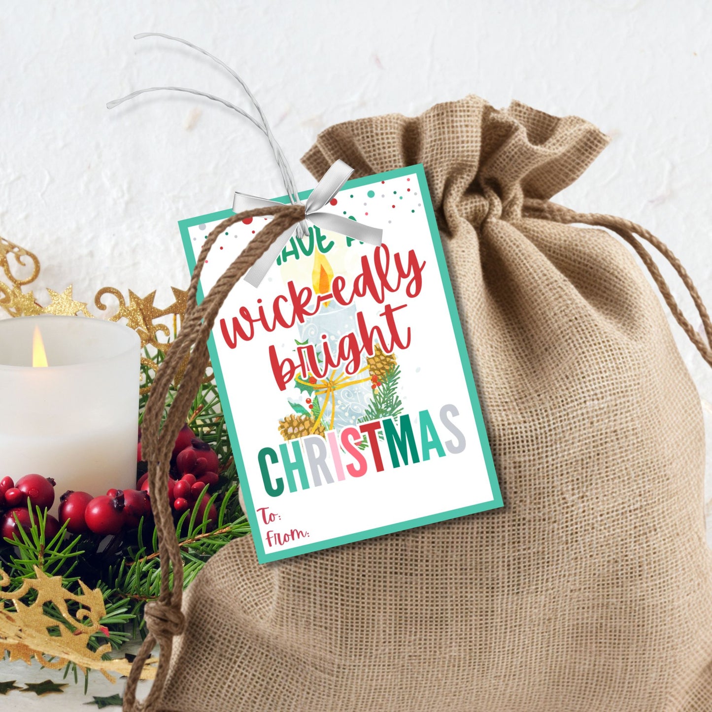 Christmas gift tags featuring a cozy candle with festive greenery and the message "Have a Wick-edly Bright Christmas." These printable and editable tags add a warm, festive touch to gifts like candles and lanterns.