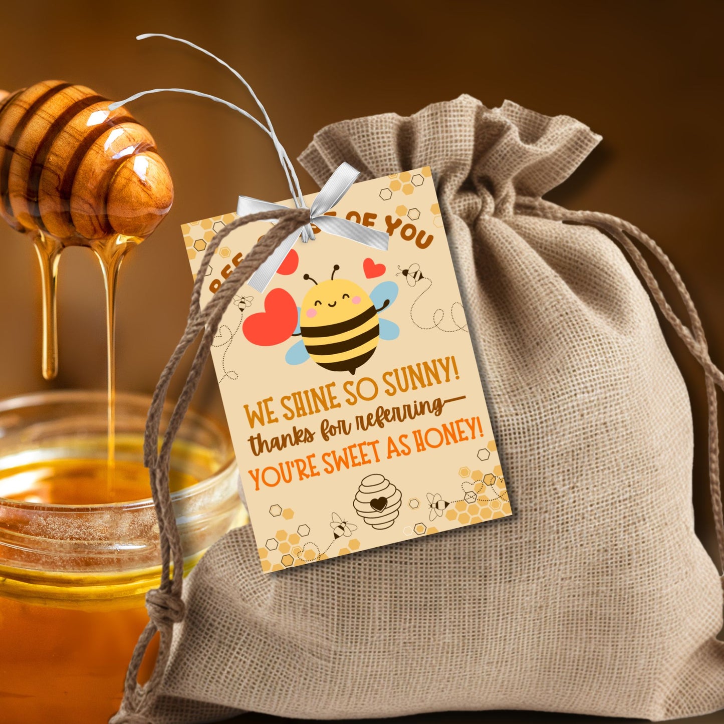 A printable PDF of referral gift tags with bee and honey themes, titled "BEE-cause of You We Shine So Sunny," editable in Canva.