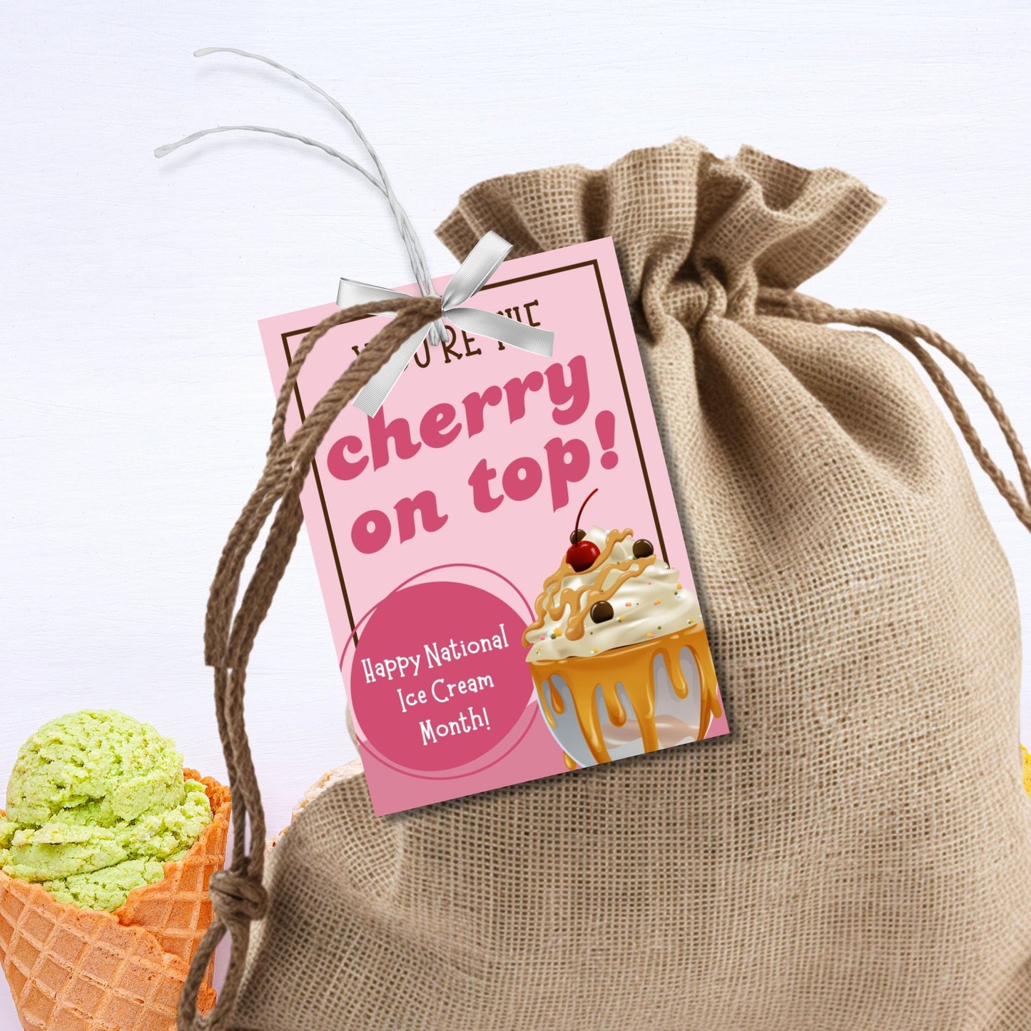 A set of colorful gift tags featuring an ice cream sundae with whipped cream, caramel syrup, and a cherry on top. The tags read "You're the Cherry on Top!" and include a customizable message for National Ice Cream Month.