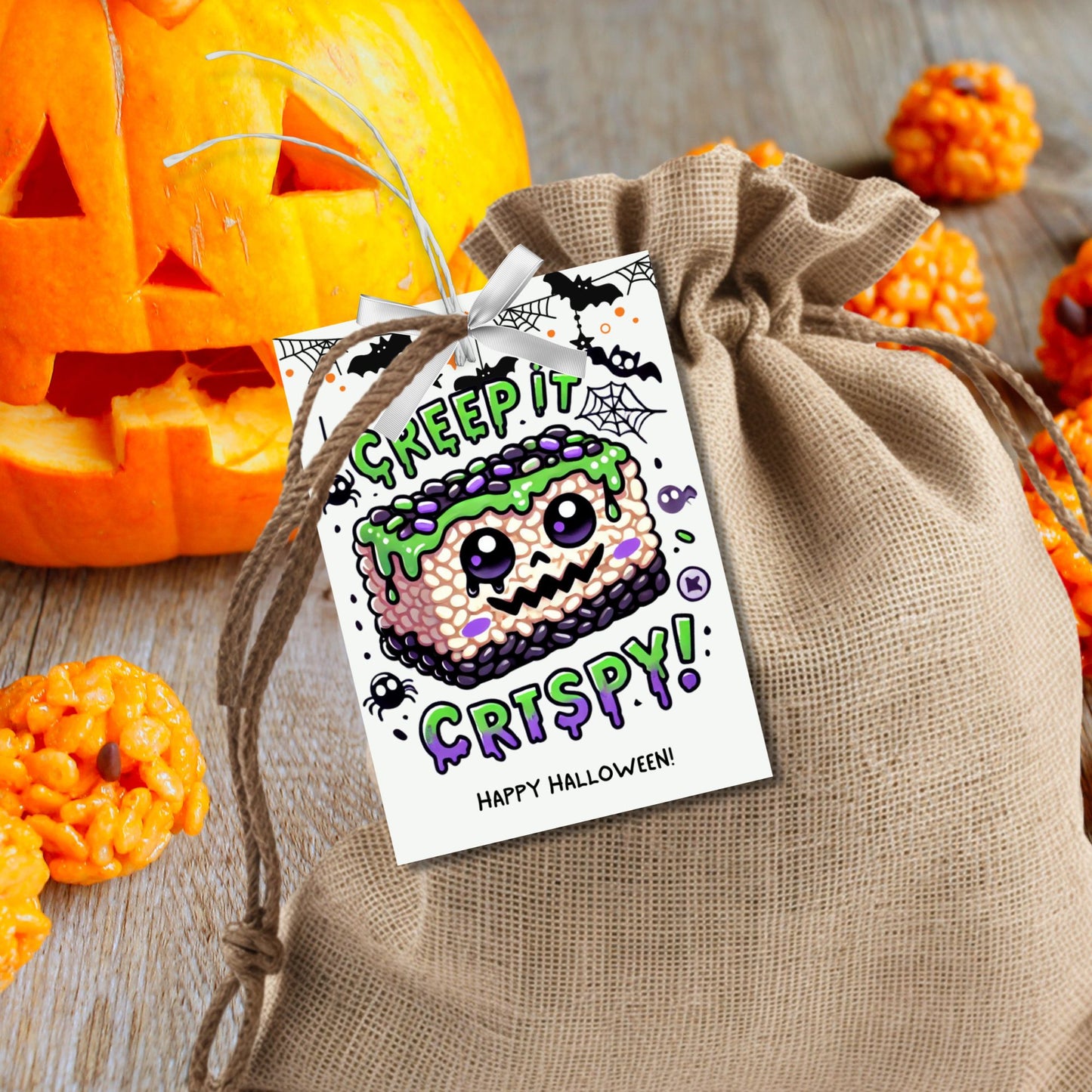 Halloween-themed printable gift tags featuring a spooky rice krispie treat with green frosting and purple sprinkles. The tag reads "Creep It Crispy!" Perfect for Halloween treats, sized 2.5 x 3.5 inches, laid out 8 per sheet. Includes a printable PDF and a link to an editable Canva template.