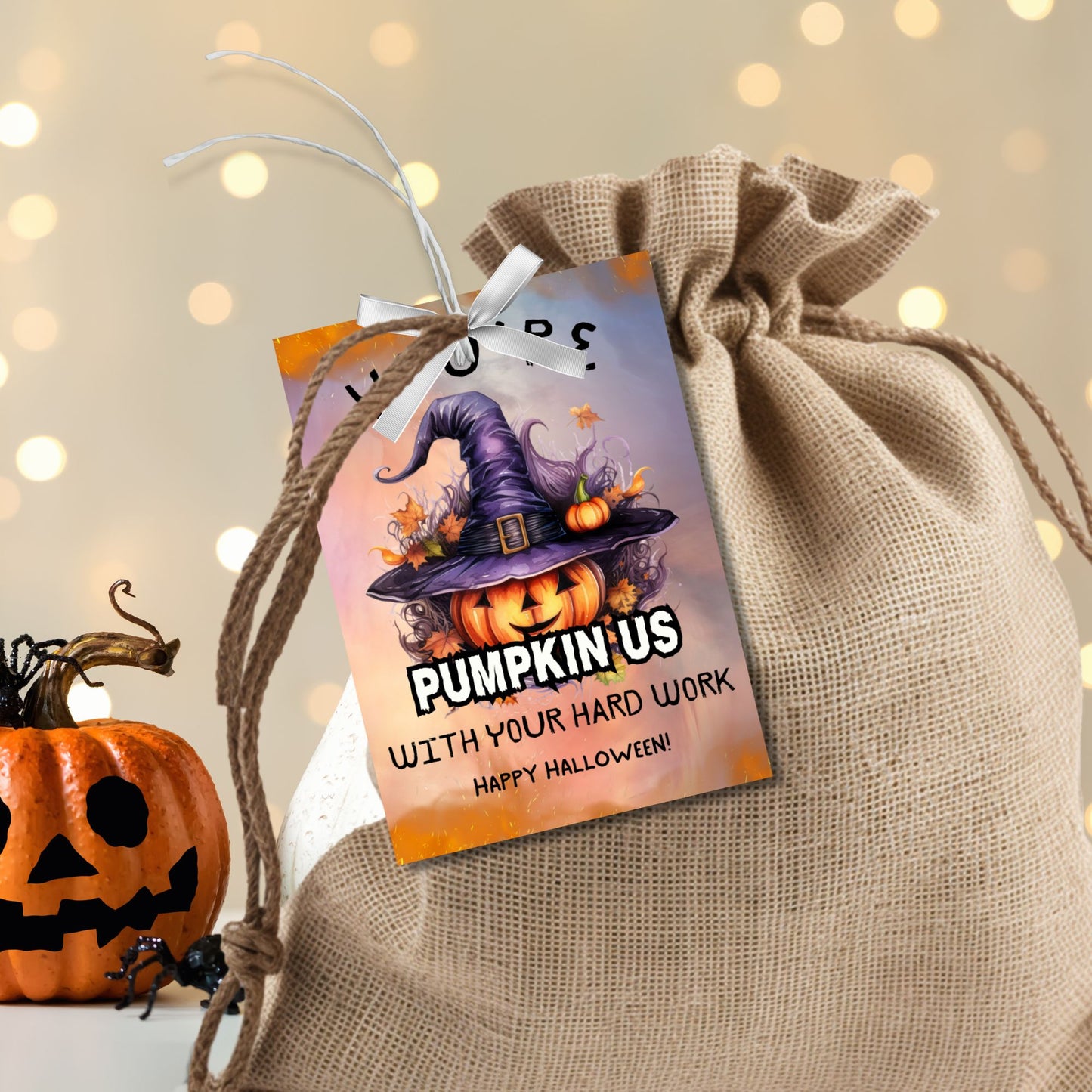 Halloween-themed printable gift tags with the message "You're Pumpkin Us With Your Hard Work" featuring a festive pumpkin in a witch's hat on a Halloween background. Tags are 2.5 x 3.5 inches, laid out 8 per sheet on a standard 8.5 x 11-inch page. Includes a printable PDF and a PDF with a link to an editable Canva template.