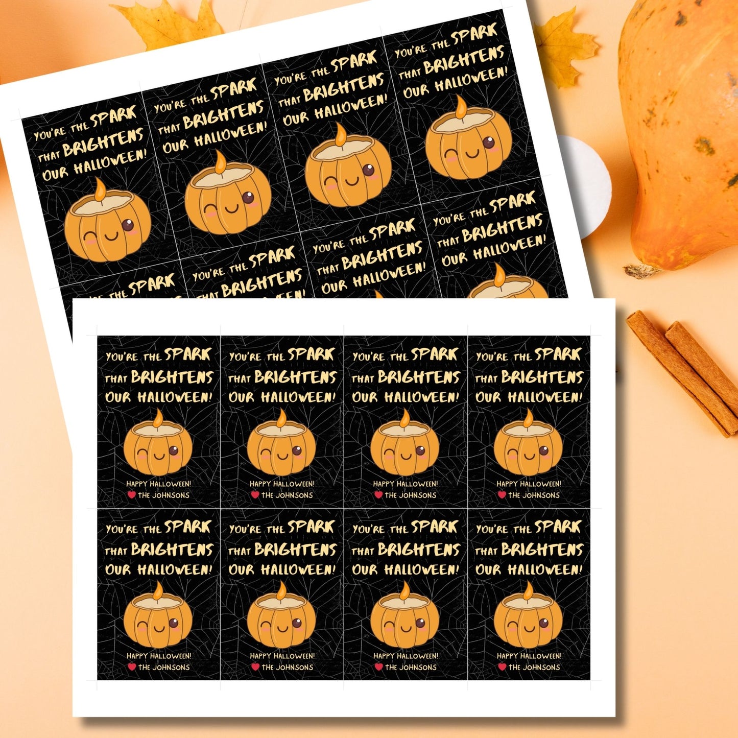 Halloween-themed printable gift tags with the message "You're the Spark that Brightens Our Halloween!" featuring a cute pumpkin candle on a black spiderweb background. Tags are 2.5 x 3.5 inches, laid out 8 per sheet on a standard 8.5 x 11-inch page. Includes a printable PDF and a PDF with a link to an editable Canva template.