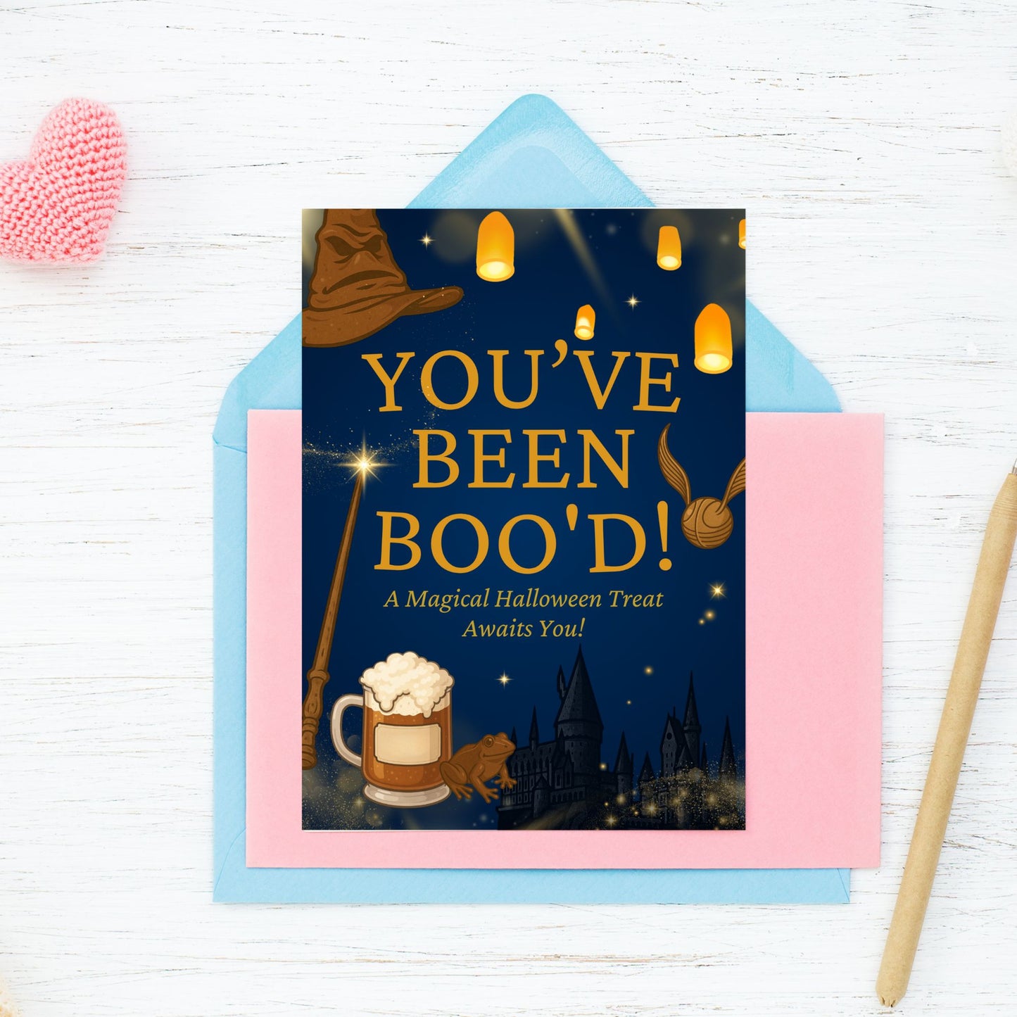 Halloween-themed 'You've Been Boo'd!' card with a blue envelope on a white wooden surface.