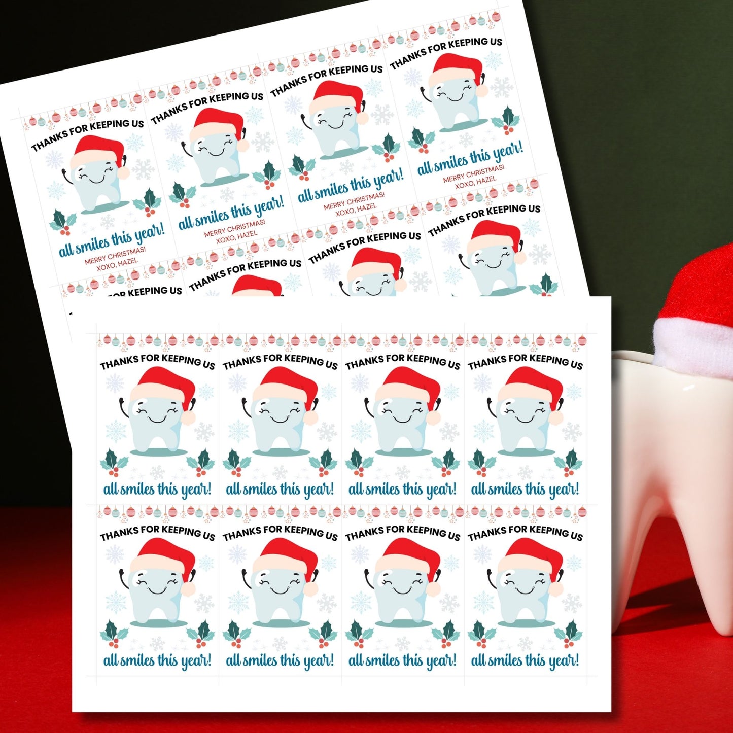 A festive set of 8 editable holiday gift tags with the message 'Thanks for Keeping Us All Smiles This Year!' featuring a smiling tooth in a Santa hat, holly, snowflakes, and hanging baubles. Perfect for dentists and dental offices to use for holiday gifts or client appreciation.