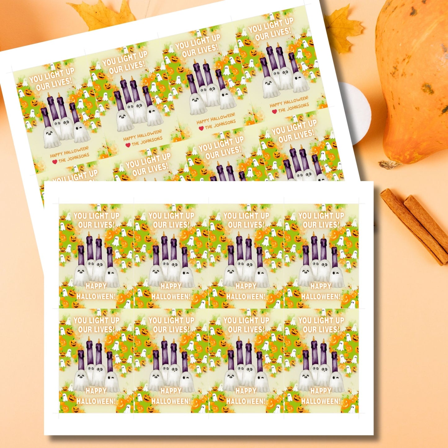 Halloween-themed printable gift tags with the message "You Light Up Our Lives!" designed for candle gifts, featuring cute ghost characters and glowing candles on a festive background. Tags are 2.5 x 3.5 inches, laid out 8 per sheet on a standard 8.5 x 11-inch page. Includes a printable PDF and a PDF with a link to an editable Canva template.