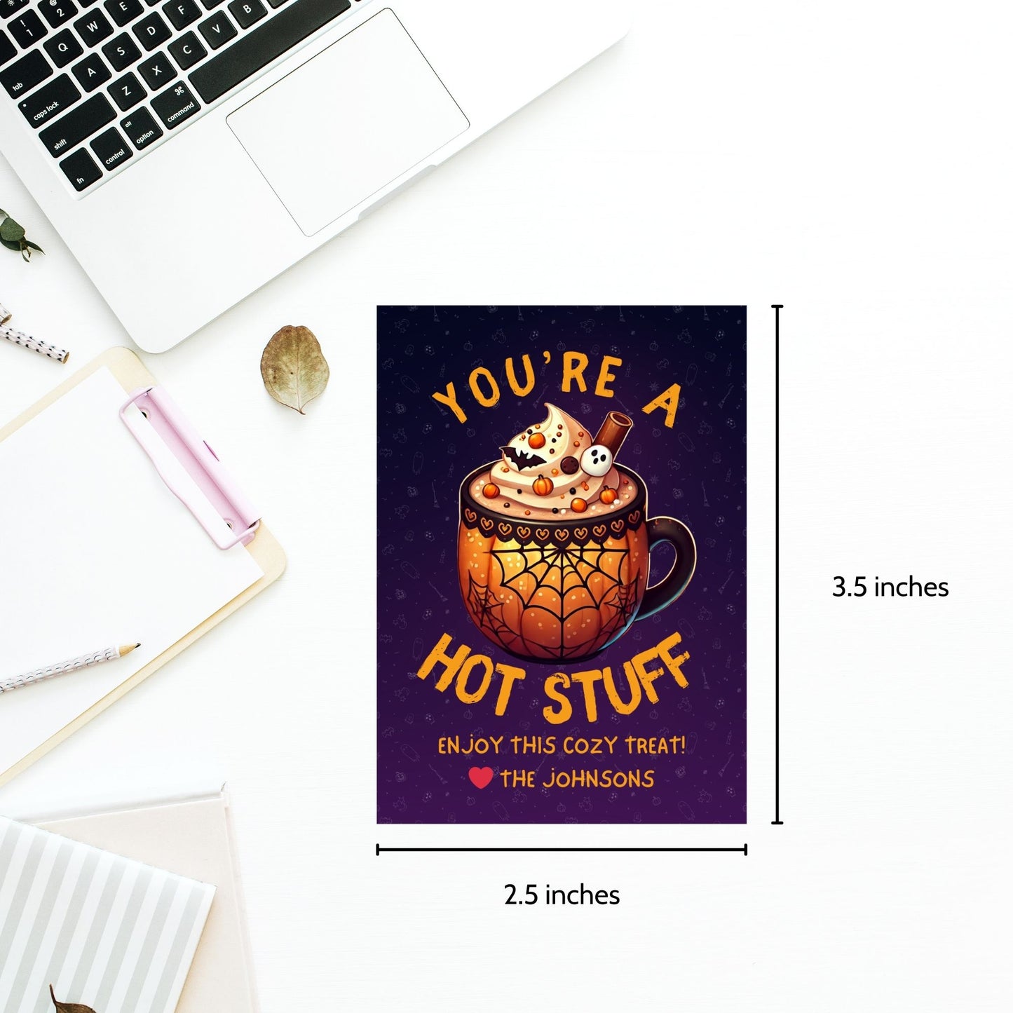 Halloween-themed printable gift tags with the message "You're a Hot Stuff" featuring a festive mug of hot cocoa on a dark purple background. Tags are 2.5 x 3.5 inches, laid out 8 per sheet on a standard 8.5 x 11-inch page. Includes a printable PDF and a PDF with a link to an editable Canva template.
