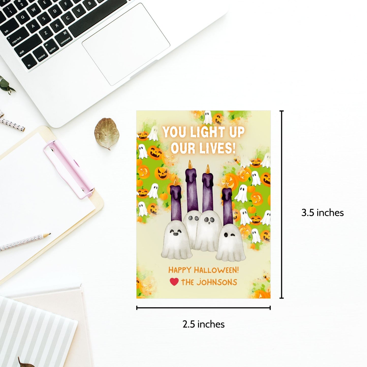 Halloween-themed printable gift tags with the message "You Light Up Our Lives!" designed for candle gifts, featuring cute ghost characters and glowing candles on a festive background. Tags are 2.5 x 3.5 inches, laid out 8 per sheet on a standard 8.5 x 11-inch page. Includes a printable PDF and a PDF with a link to an editable Canva template.
