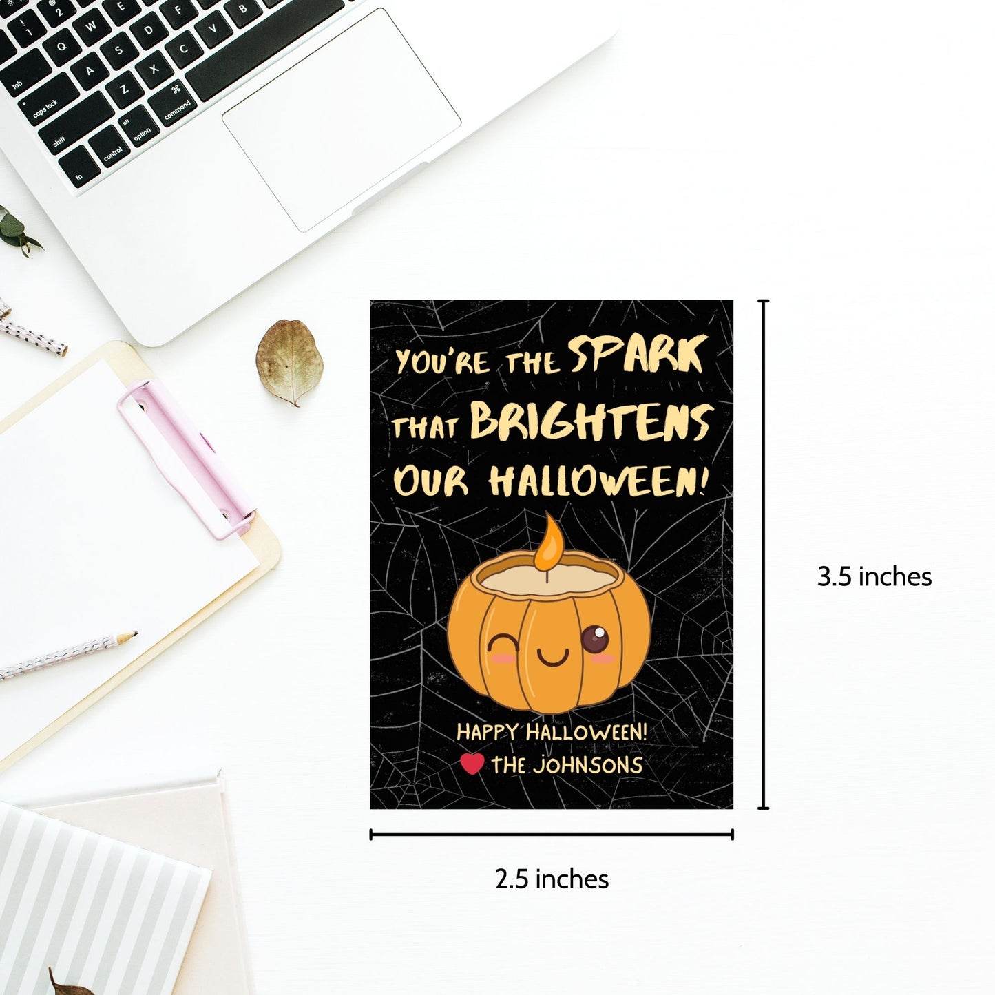 Halloween-themed printable gift tags with the message "You're the Spark that Brightens Our Halloween!" featuring a cute pumpkin candle on a black spiderweb background. Tags are 2.5 x 3.5 inches, laid out 8 per sheet on a standard 8.5 x 11-inch page. Includes a printable PDF and a PDF with a link to an editable Canva template.