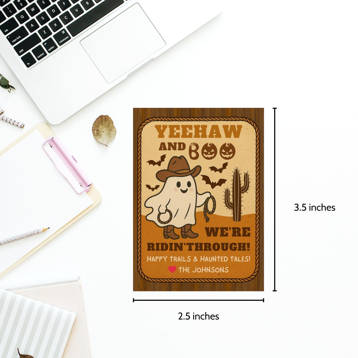 Ghost in a cowboy hat with text on a wooden plaque, placed on a desk with a laptop.