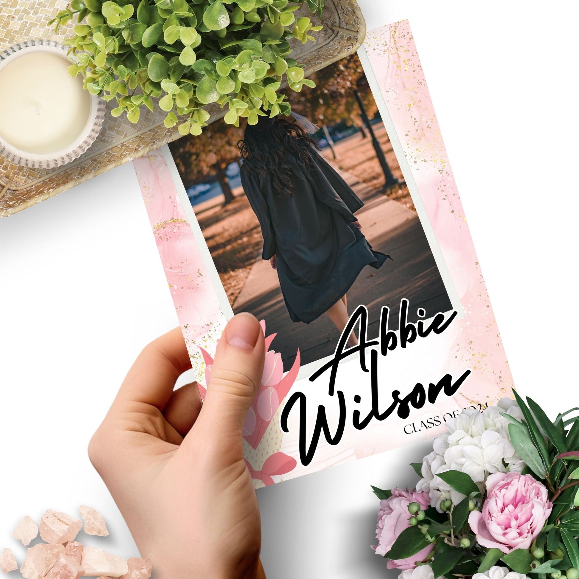 Elegant double-sided graduation party invitation with a vibrant front featuring a graduate walking and a detailed back with event specifics, all set against a charming pink watercolor background with floral motifs.