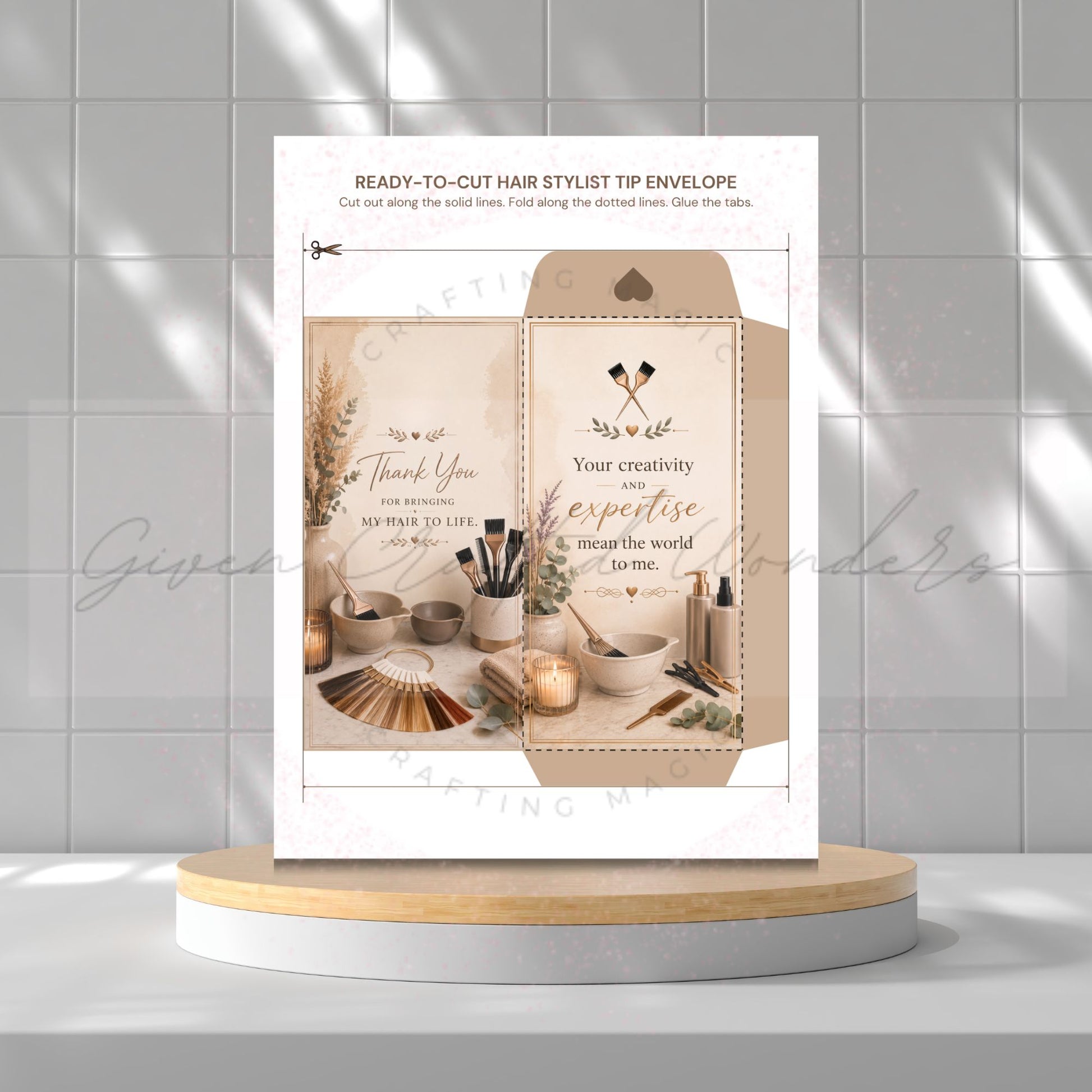 A ready-to-cut hair stylist tip envelope card set displayed on a light wood and white round pedestal against a gray tiled wall. The set includes a white envelope with printed text and a kraft paper envelope featuring a beige background, decorative hair tools, and styling accessories.