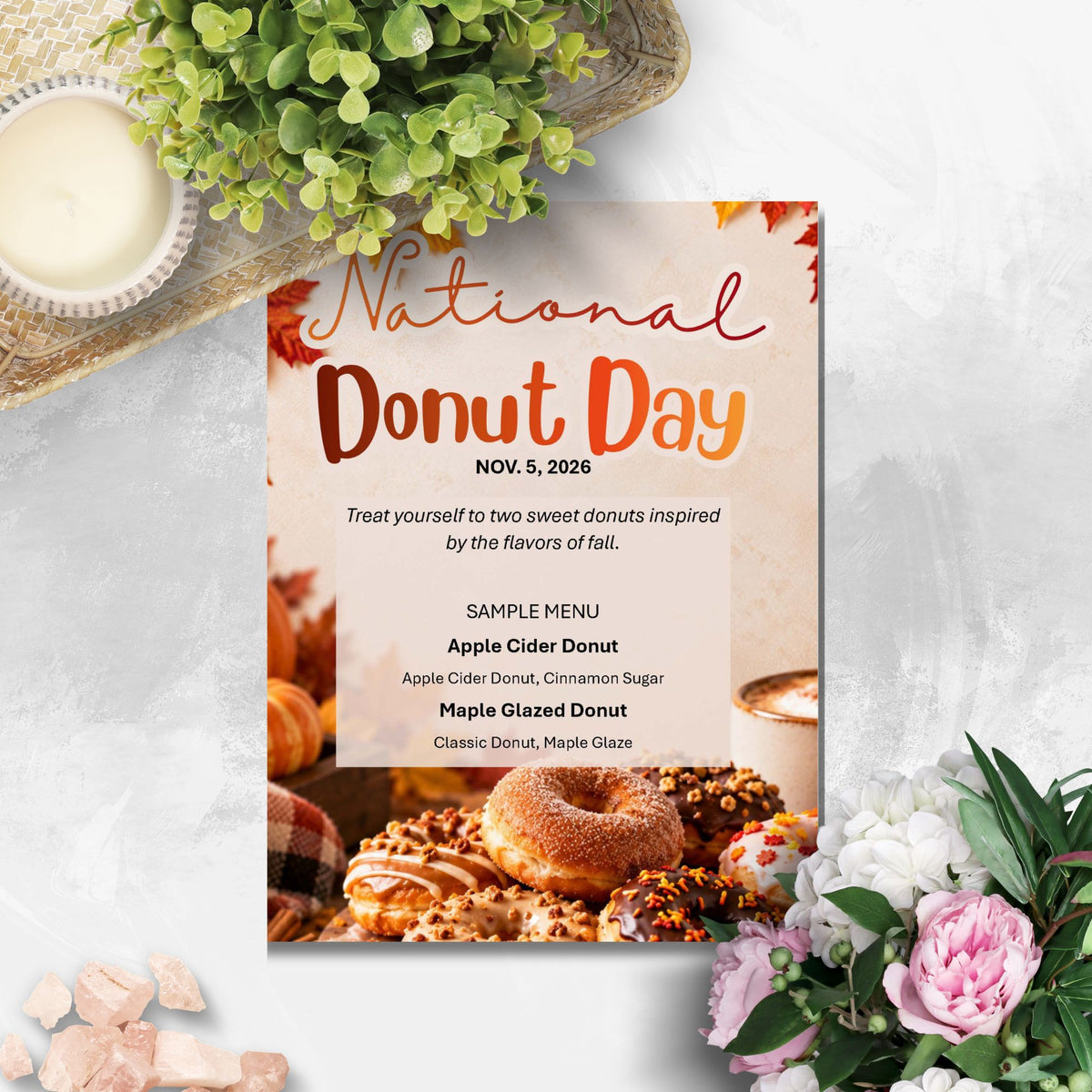 A National Donut Day event flyer template styled in a flat-lay arrangement with autumn leaves, a green plant, a pink rose, and a cup of coffee on a light gray marble background.