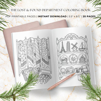A styled flat-lay of an open coloring book showing two black-and-white illustrated interior pages, with a blush pink notebook cover peeking out on the left. Text at the top reads 'THE LOST & FOUND DEPARTMENT COLORING BOOK' and 'PDF PRINTABLE PAGES | INSTANT DOWNLOAD | 5.