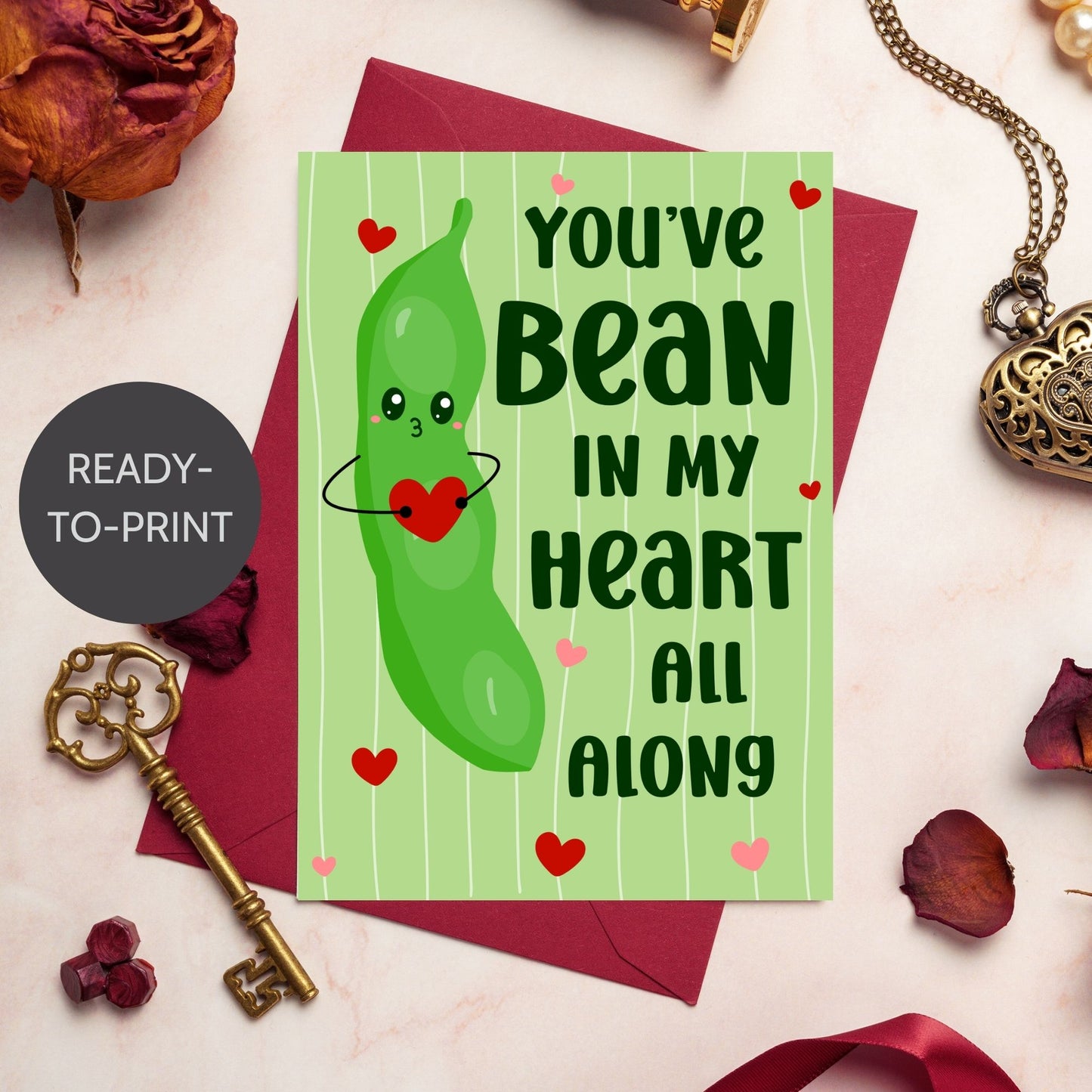 Printable Valentine’s Day Greeting Card featuring the phrase “You’ve Bean in My Heart All Along” with a cute bean design. Designed as a 5x7 PDF on an 8.5 x 11 sheet with two cards per page. A punny and heartfelt Valentine’s card for loved ones.