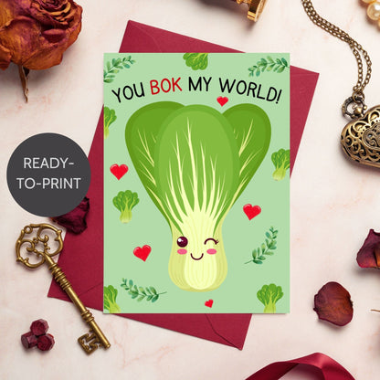 Printable Valentine’s Day Greeting Card featuring the phrase “You Bok My World” with a fun bok choy illustration. Designed as a 5x7 PDF on an 8.5 x 11 sheet with two cards per page. A cute and punny Valentine’s card for veggie lovers and friends.