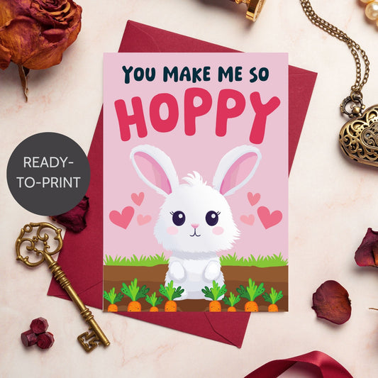 Printable Valentine’s Day Greeting Card featuring the pun “You Make Me So Hoppy.” Designed as a 5x7 PDF on an 8.5 x 11 sheet with two cards per page. A fun and cute Valentine’s card for bunny lovers.