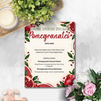 A decorative pomegranate-themed menu card or flyer styled on a light stone surface with greenery, flowers, and pink stones around it. The card has red pomegranate illustrations, green leaves, and the headline 'Seasonal Superfood Spotlighting Pomegranates' with placeholder text below.