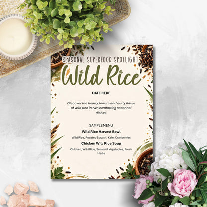 A printed menu card titled 'Seasonal Superfood Spotlight: Wild Rice' styled on a light stone surface with greenery, a candle, and pink flowers around it.