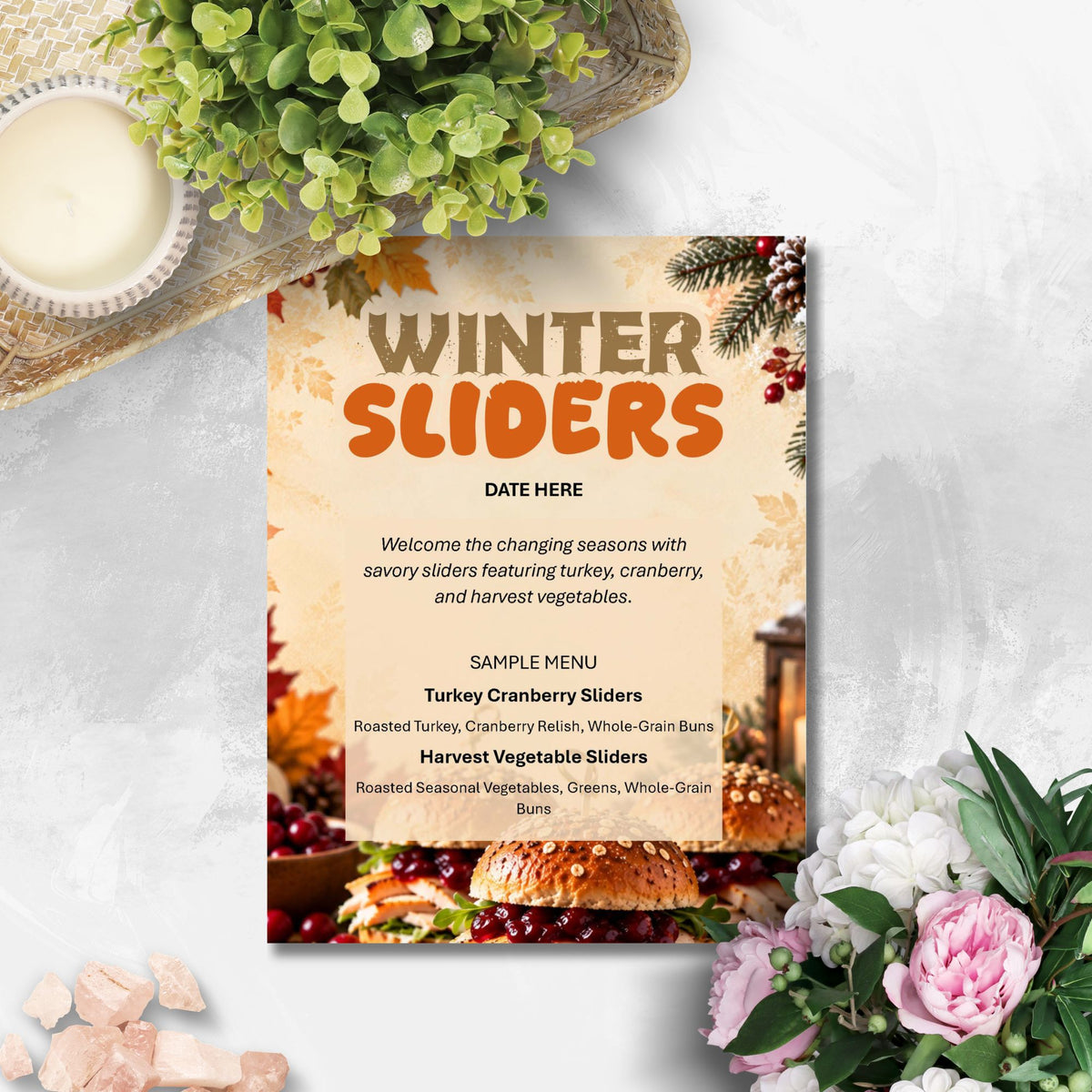 A decorative restaurant menu card titled 'WINTER SLIDERS' styled on a light stone surface with seasonal props including greenery, flowers, and a candle. The menu features a warm beige background with orange and brown typography and food photography at the bottom.
