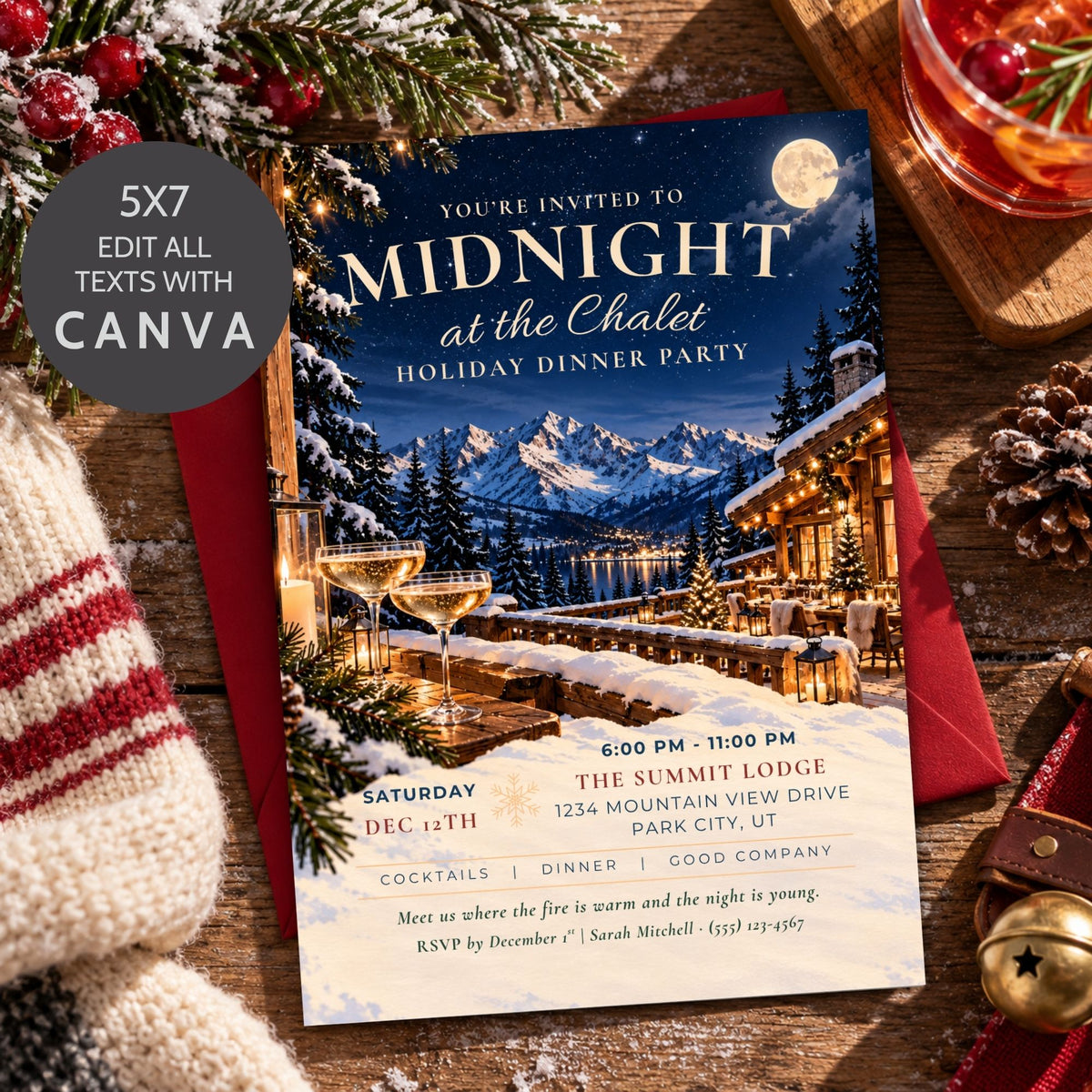 A holiday dinner party invitation card styled on a rustic wooden table with a red envelope, a striped knit sweater, pinecones, and a glass of red wine. The invitation features a winter mountain lodge scene with a moon, snow-covered trees, and two champagne glasses.