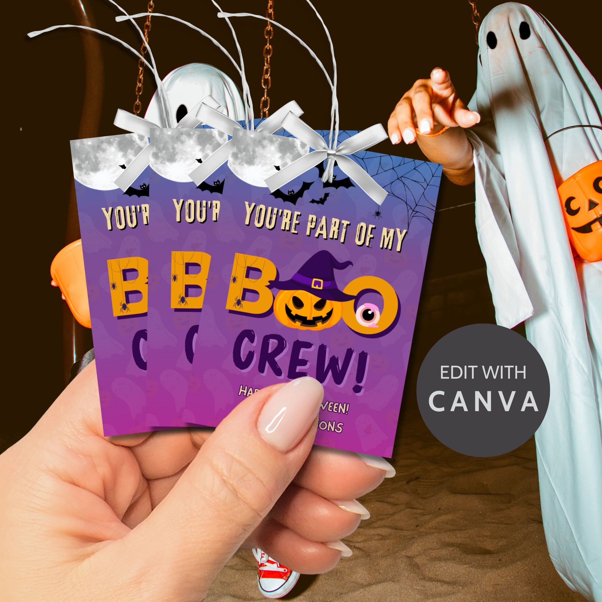 Halloween-themed card with text 'Your're part of my Boo Crew!' held by a hand, with ghost decorations in the background.