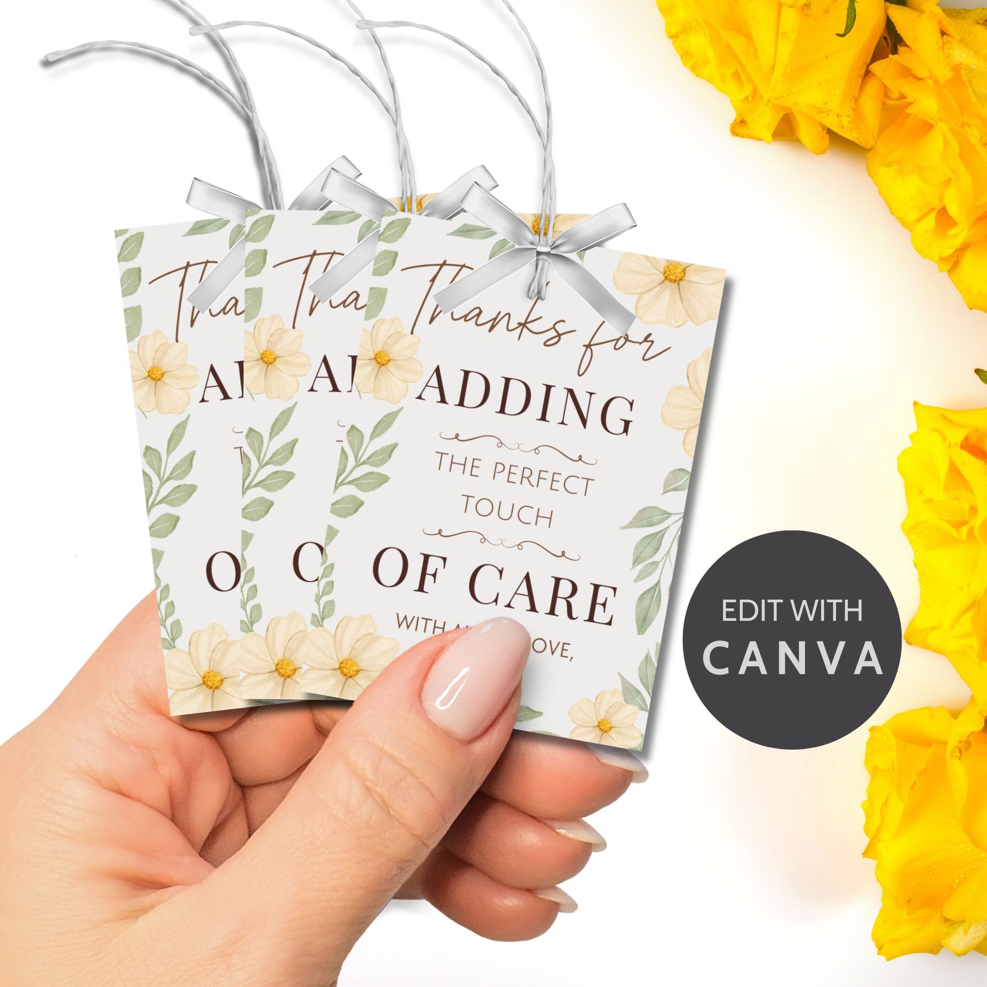 Decorative gift tag held by a hand with yellow flowers in the background, featuring text and 'Edit with Canva' logo.