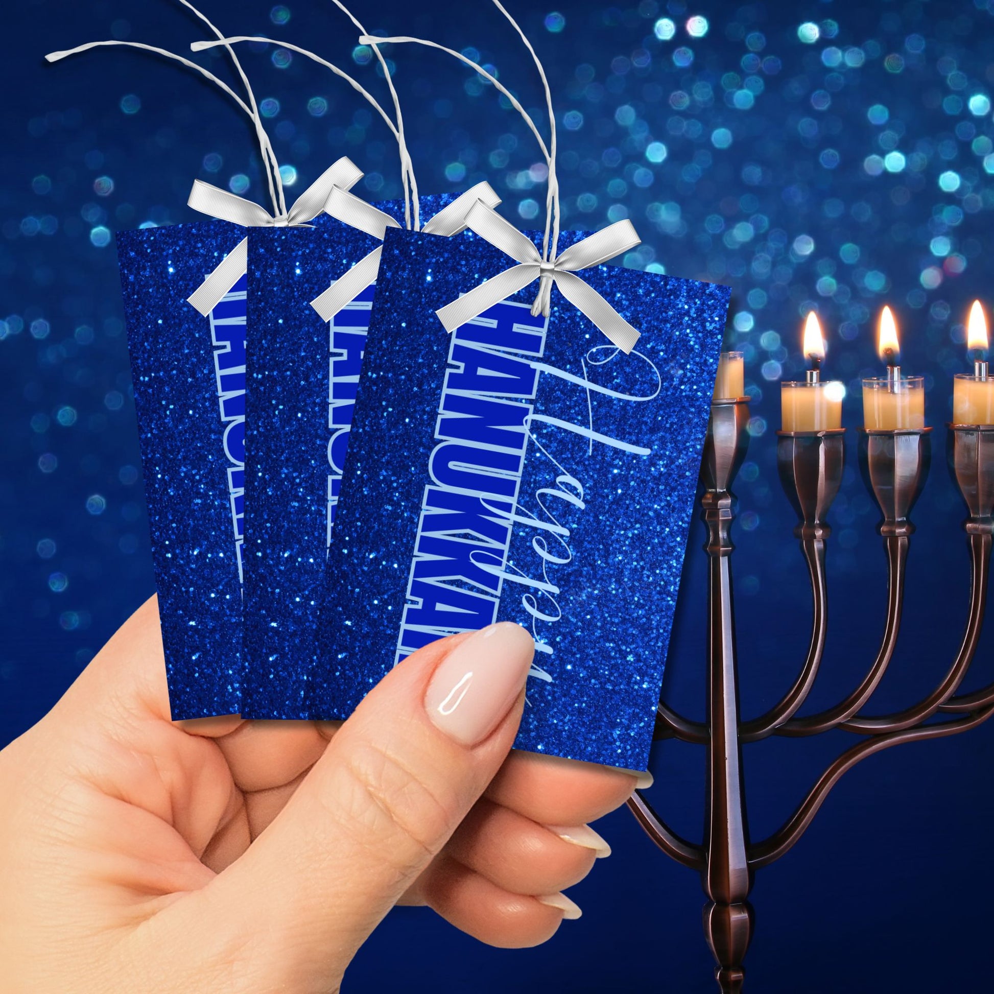 A set of printable Hanukkah gift tags featuring "Happy Hanukkah" in white and blue text on a sparkling blue glitter background. Perfect for Hanukkah gift wrapping.