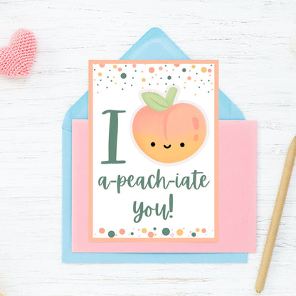 Printable Valentine’s Day Greeting Card featuring the phrase “I APEACHiate You” with a peach illustration. Designed as a 5x7 PDF on an 8.5 x 11 sheet with two cards per page. A fun and punny Valentine’s card for loved ones.