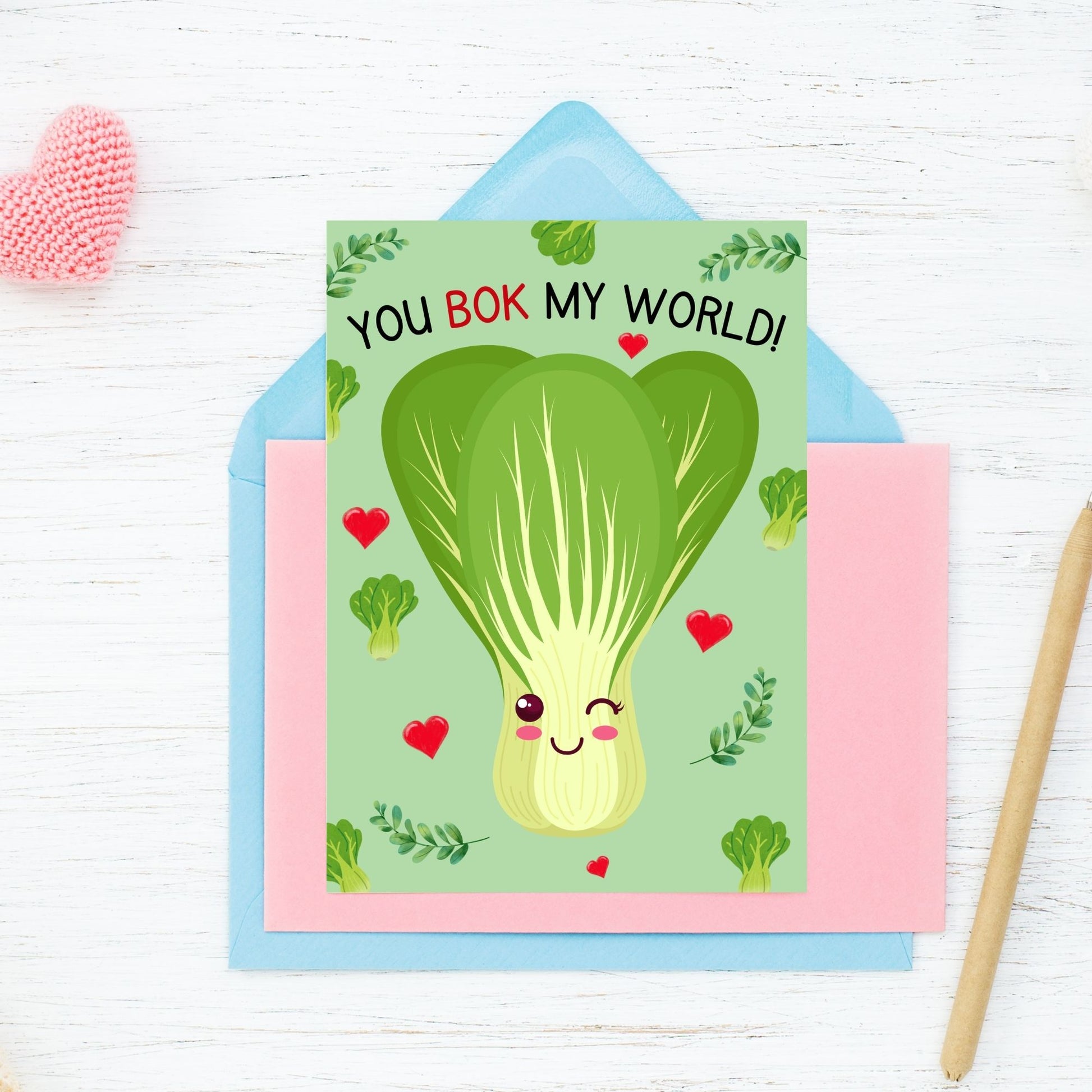 Printable Valentine’s Day Greeting Card featuring the phrase “You Bok My World” with a fun bok choy illustration. Designed as a 5x7 PDF on an 8.5 x 11 sheet with two cards per page. A cute and punny Valentine’s card for veggie lovers and friends.