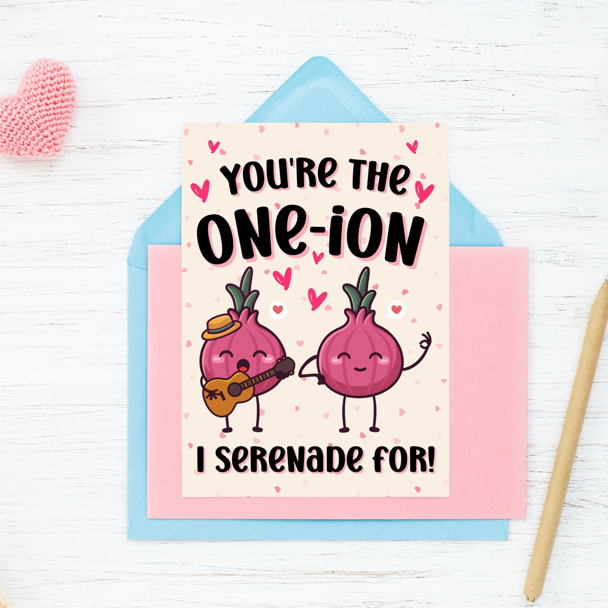 Printable Valentine’s Day Greeting Card featuring the phrase “You’re the One-ion a Serenade For” with a playful onion illustration. Designed as a 5x7 PDF on an 8.5 x 11 sheet with two cards per page. A punny and charming Valentine’s card for loved ones.