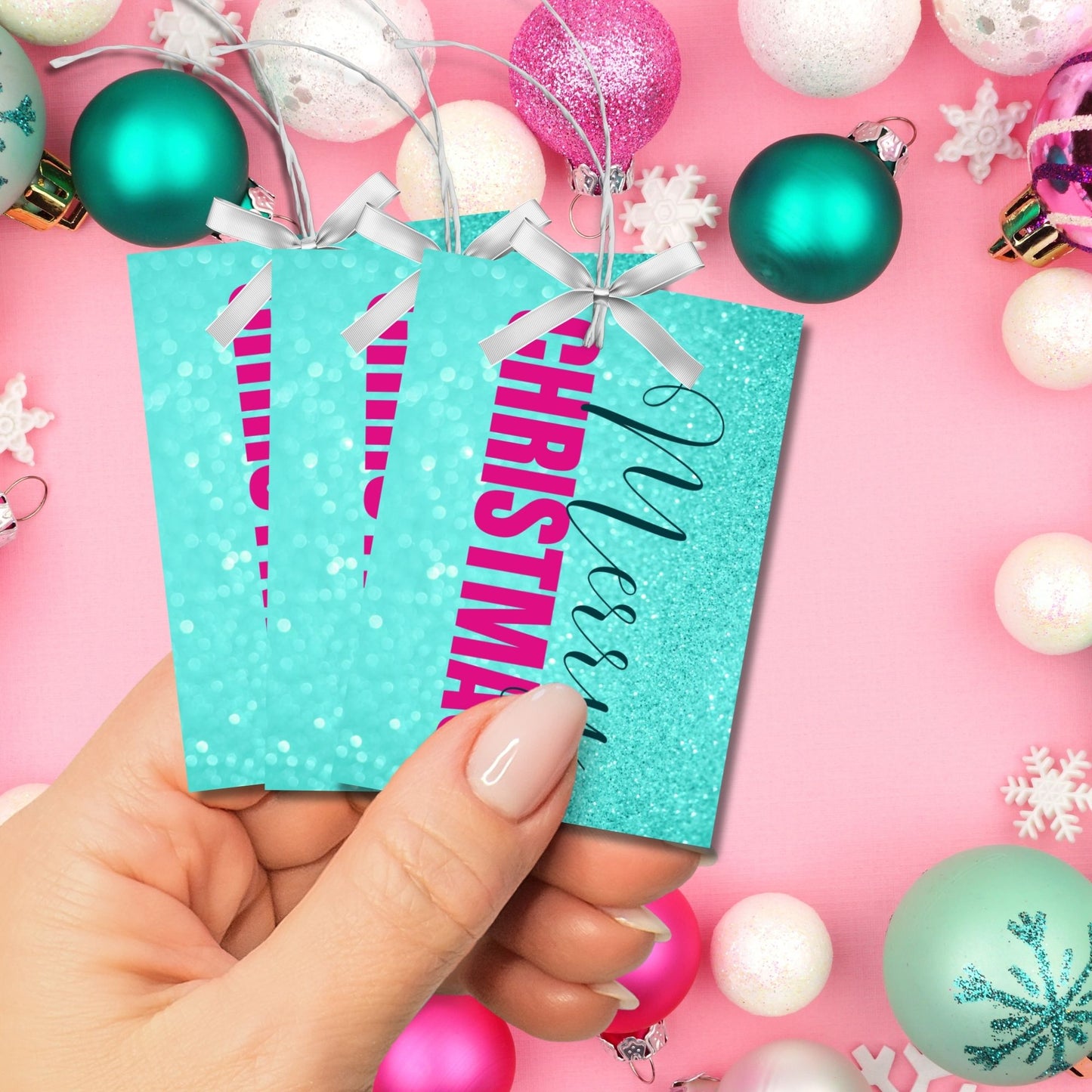 Printable Christmas gift tags featuring an aqua glitter background with bold magenta "Merry Christmas" text and black script accents, sized 2.5 x 3.5 inches, 8 tags per sheet.