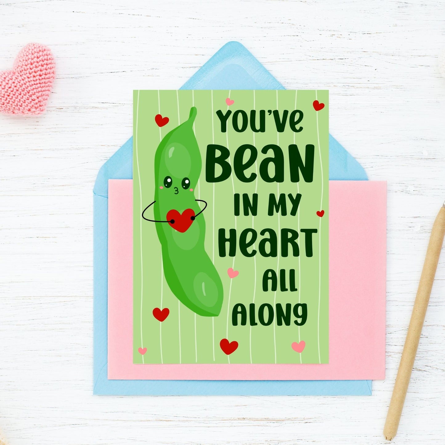 Printable Valentine’s Day Greeting Card featuring the phrase “You’ve Bean in My Heart All Along” with a cute bean design. Designed as a 5x7 PDF on an 8.5 x 11 sheet with two cards per page. A punny and heartfelt Valentine’s card for loved ones.