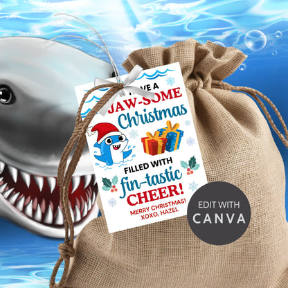 Festive shark-themed holiday gift tags featuring a smiling shark wearing a Santa hat, surrounded by waves, holly, and presents, with the message 'Have a JAW-some Christmas filled with fin-tastic cheer!' Perfect for personalized Christmas gifts.