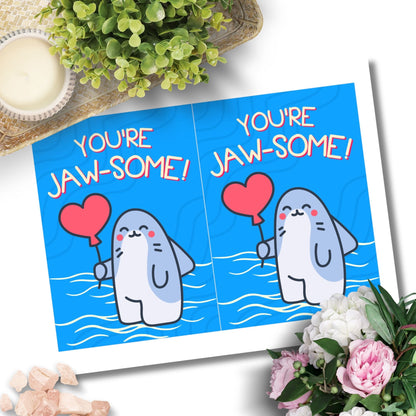 Printable Valentine’s Day Greeting Card featuring the phrase “You’re Jawsome” with a shark theme. Designed as a 5x7 PDF on an 8.5 x 11 sheet with two cards per page. A fun and unique Valentine’s card for shark lovers.