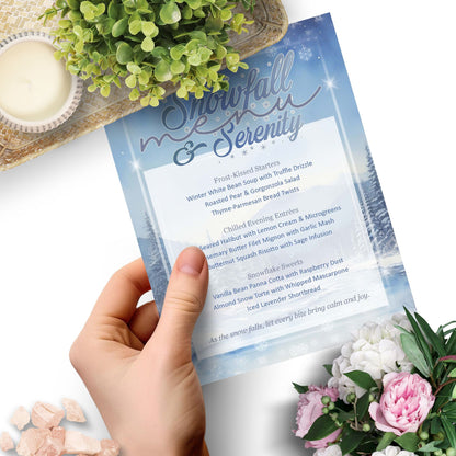 Hand holding a menu with 'Snowfall Menu' design, surrounded by flowers and a plant.
