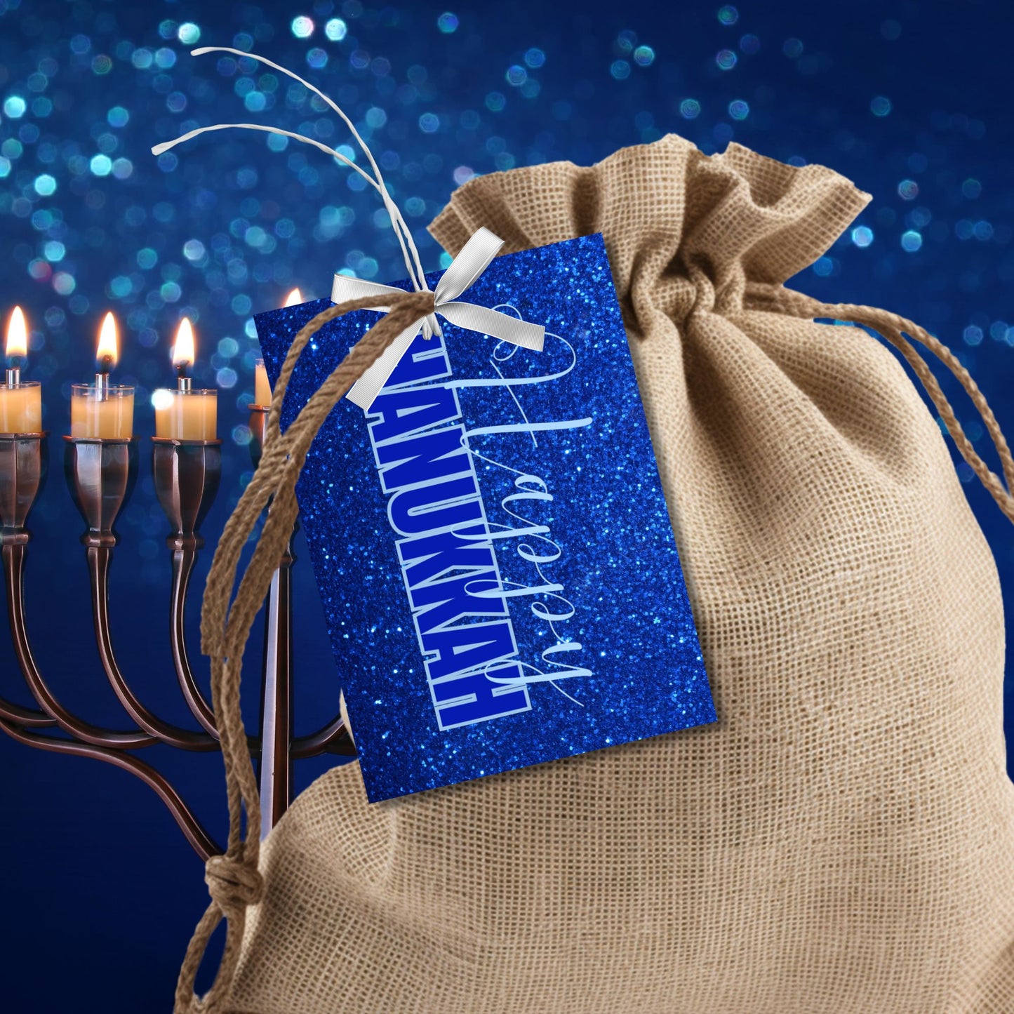 A set of printable Hanukkah gift tags featuring "Happy Hanukkah" in white and blue text on a sparkling blue glitter background. Perfect for Hanukkah gift wrapping.