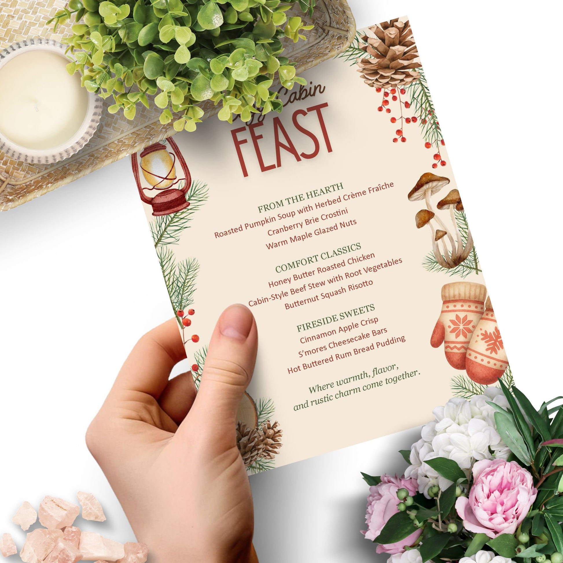 Menu titled 'Cabin Feast' held by a hand with decorative elements like flowers and candles.