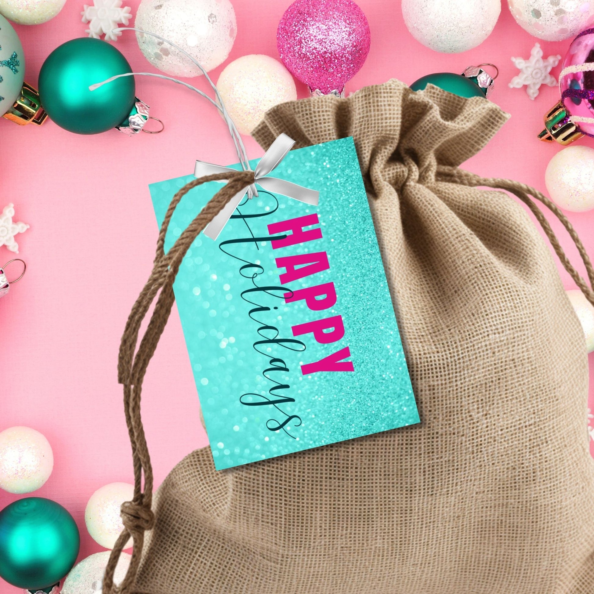 Printable Holiday gift tags featuring an aqua glitter background with bold magenta "Happy Holidays" text and black script accents, sized 2.5 x 3.5 inches, 8 tags per sheet.