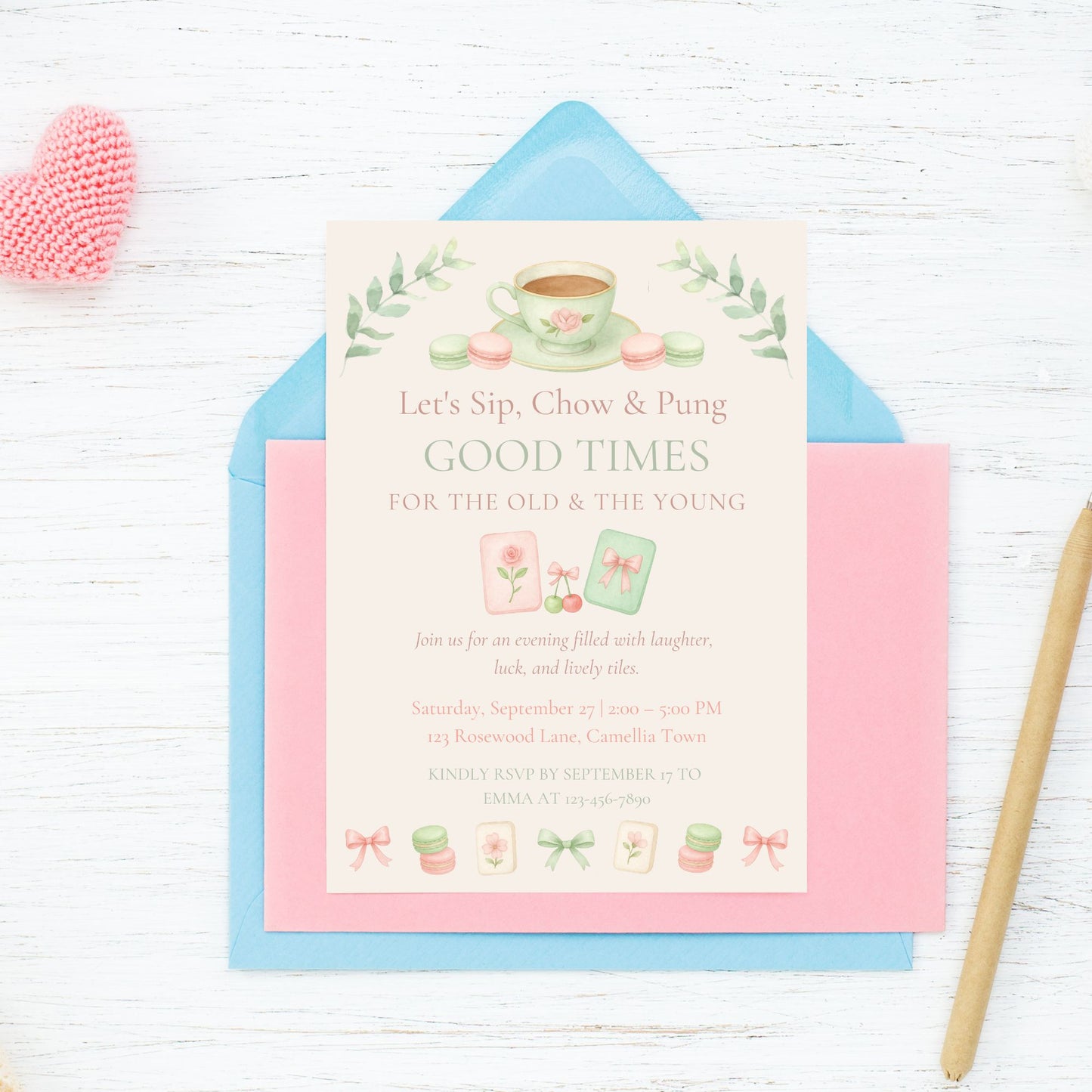 Invitation card with tea-themed design on a white wooden surface