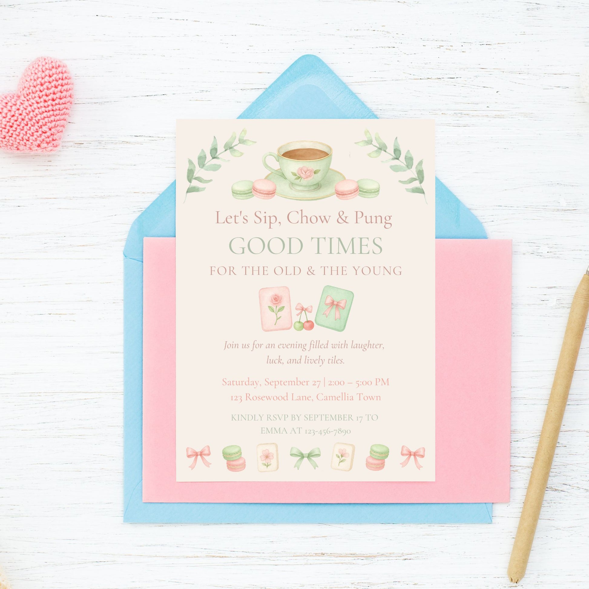 Invitation card with tea-themed design on a white wooden surface