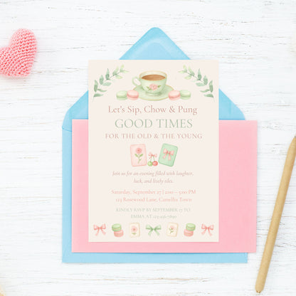 Invitation card with tea-themed design on a white wooden surface