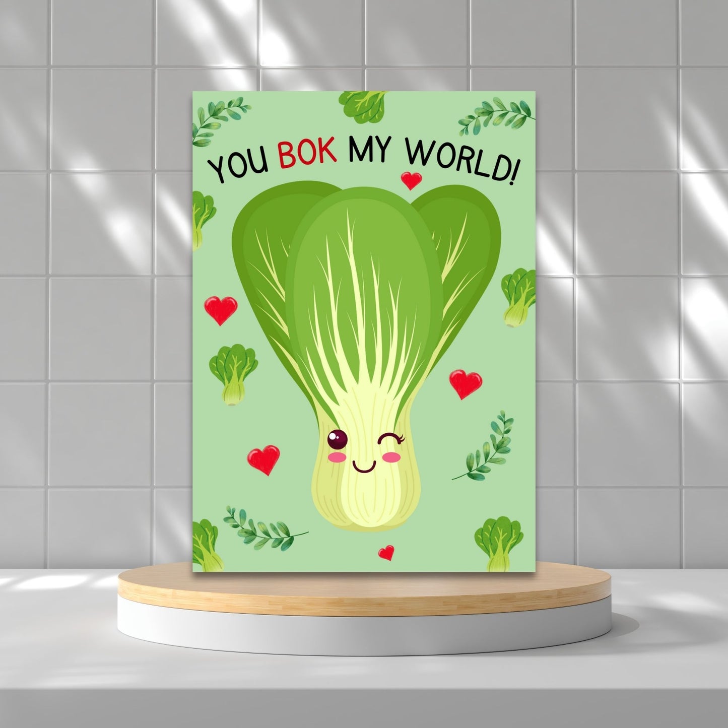 Printable Valentine’s Day Greeting Card featuring the phrase “You Bok My World” with a fun bok choy illustration. Designed as a 5x7 PDF on an 8.5 x 11 sheet with two cards per page. A cute and punny Valentine’s card for veggie lovers and friends.