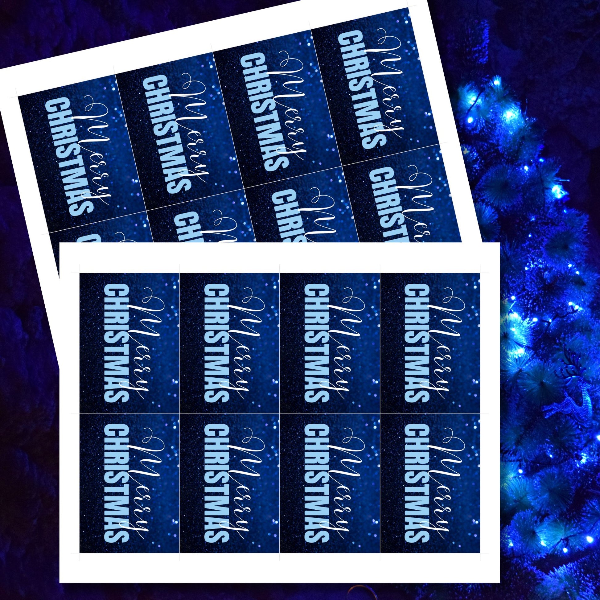 Printable blue Christmas gift tags with a glittery blue background and bold light blue "Merry Christmas" text, sized 2.5 x 3.5 inches, 8 tags per sheet.