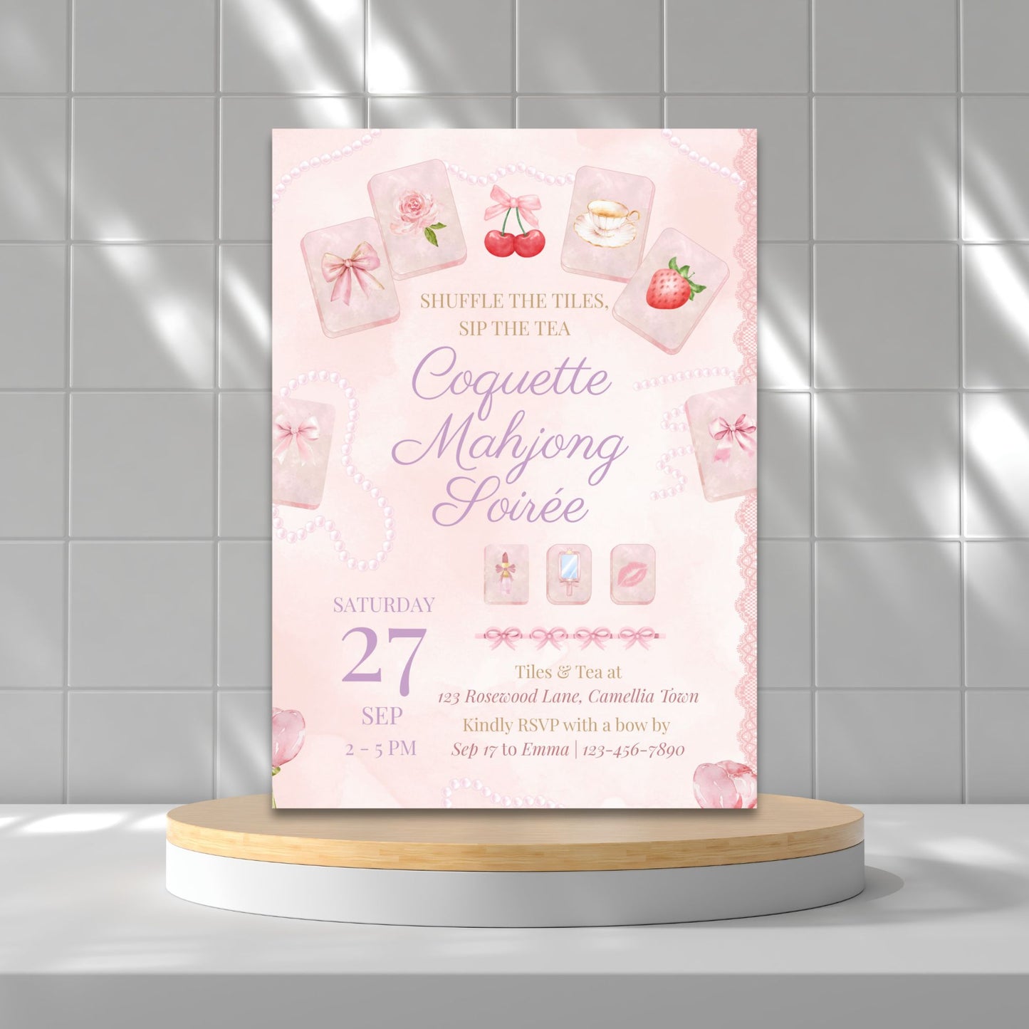 Pink event invitation card on a round wooden platform with a tiled wall background